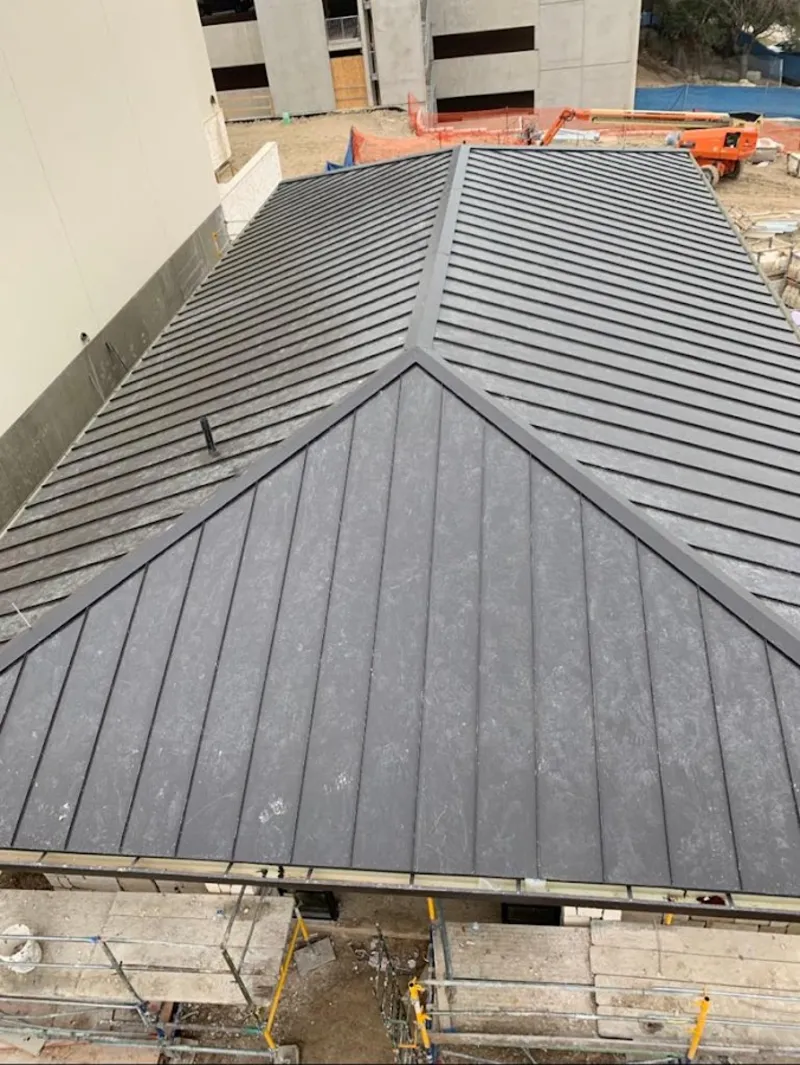 Commercial metal roof construction with crane equipment in Marinette